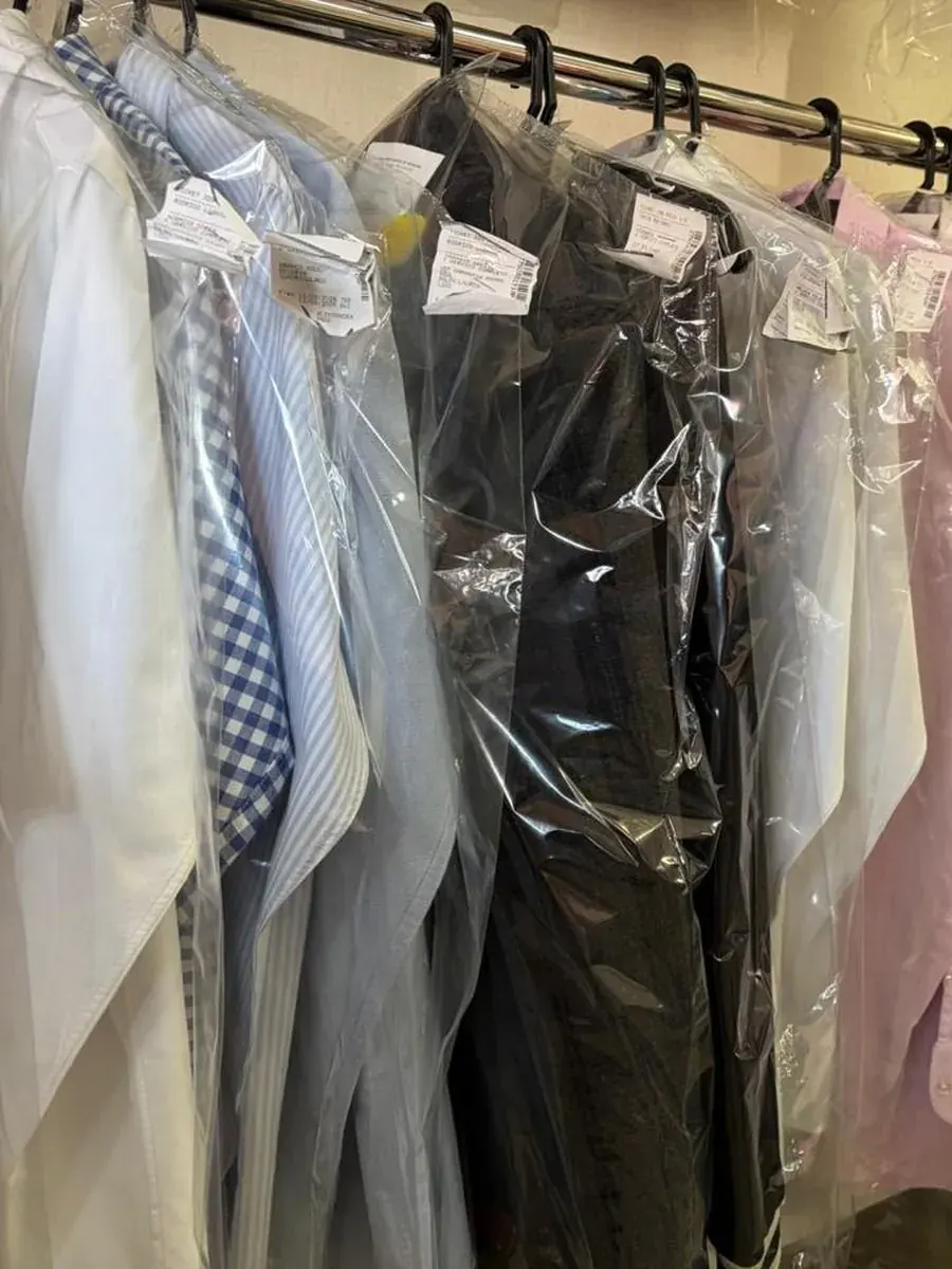 Arara com camisas, ternos e vestidos embalados após a lavagem